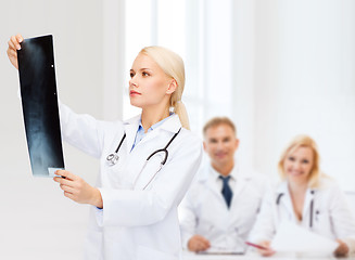 Image showing serious female doctor looking at x-ray