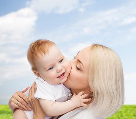 Image showing happy mother kissing smiling baby