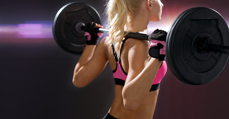 Image showing sporty woman exercising with barbell from back