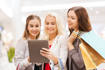 Image showing happy young women with tablet pc and shopping bags