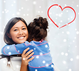 Image showing smiling little girl and mother hugging indoors