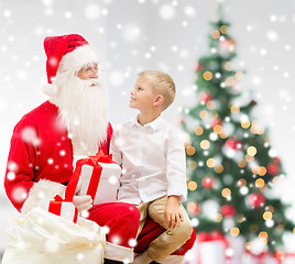 Image showing smiling little boy with santa claus and gifts