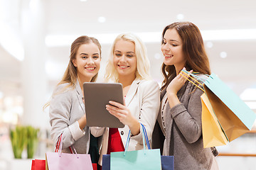 Image showing happy young women with tablet pc and shopping bags