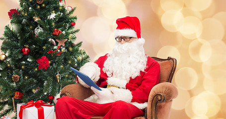 Image showing man in costume of santa claus with tablet pc