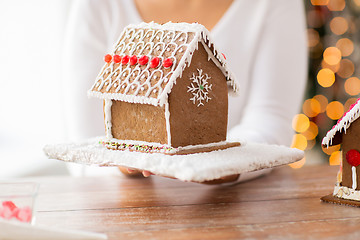 Image showing close up of woman showing gingerbread house