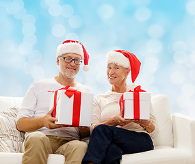 Image showing happy senior couple in santa hats with gift boxes