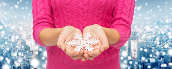 Image showing close up of woman in sweater holding snowflake