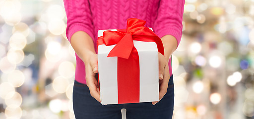 Image showing close up of woman in pink sweater holding gift box