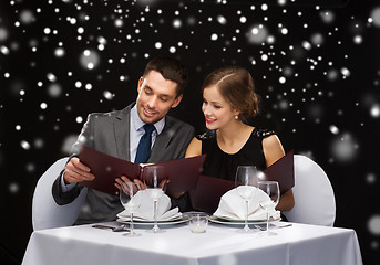 Image showing smiling couple with menus at restaurant