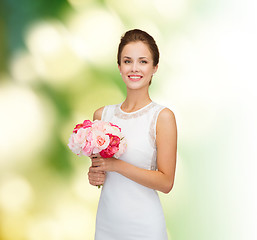 Image showing smiling woman in white dress with bouquet of roses