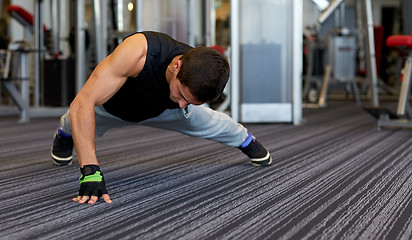 Image showing man one arm push-ups in gym