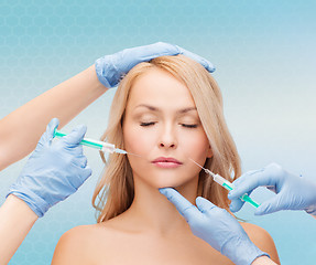 Image showing woman face and beautician hands with syringes