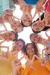 Image showing group of smiling teenagers showing victory sign