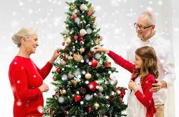 Image showing smiling family decorating christmas tree at home