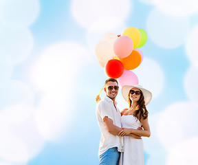 Image showing smiling couple with air balloons outdoors