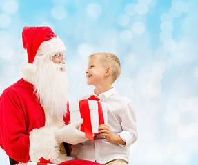 Image showing smiling little boy with santa claus and gifts