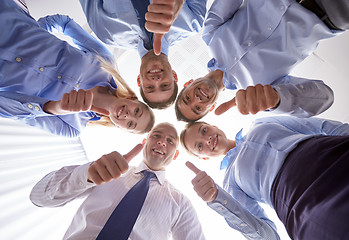 Image showing smiling group of businesspeople standing in circle