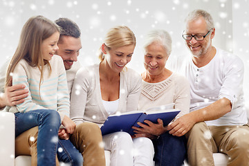 Image showing happy family with book or photo album at home