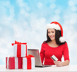 Image showing smiling woman with gifts, laptop and credit card