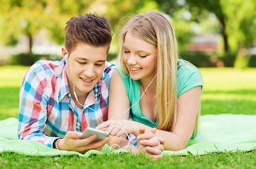 Image showing smiling couple with smartphone and earphones