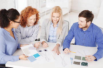 Image showing smiling creative team looking at sketch