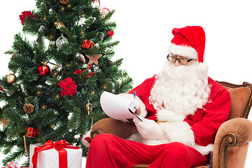 Image showing man in costume of santa claus with notepad