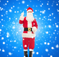 Image showing man in costume of santa claus pointing finger up