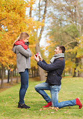 Image showing smiling couple with engagement ring in gift box