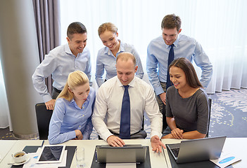 Image showing smiling business people with laptop in office