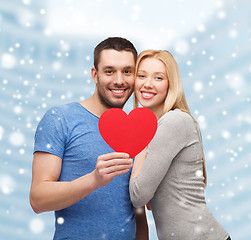 Image showing happy couple with red heart shape hugging outdoors