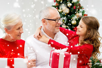 Image showing smiling family with gifts at home