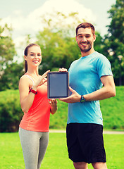 Image showing smiling couple with tablet pc outdoors