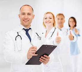 Image showing smiling male doctor with clipboard and stethoscope