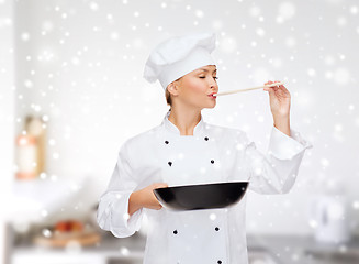 Image showing smiling female chef with pan and spoon