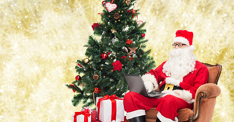 Image showing man in costume of santa claus with laptop