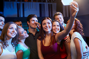 Image showing friends with smartphone taking selfie in club