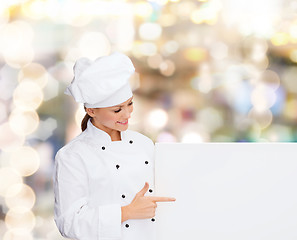 Image showing smiling female chef with white blank board