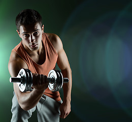 Image showing young man with dumbbell flexing biceps