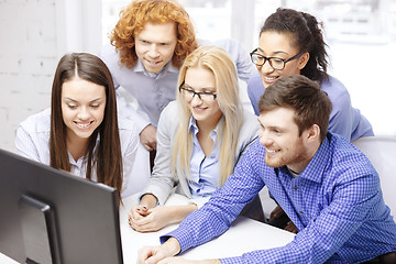 Image showing smiling business team looking at computer monitor