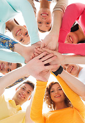 Image showing smiling teenagers with hands on top of each other