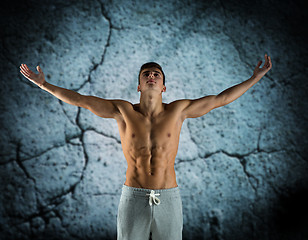 Image showing young male bodybuilder with raised hands