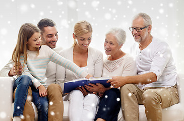 Image showing happy family with book or photo album at home