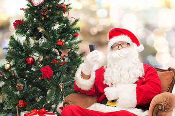 Image showing santa claus with smartphone and christmas tree