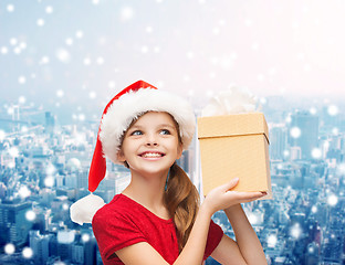 Image showing smiling girl in santa helper hat with gift box