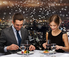 Image showing smiling couple eating main course at restaurant