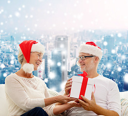 Image showing happy senior couple with gift box at home