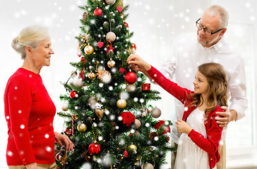 Image showing smiling family decorating christmas tree at home