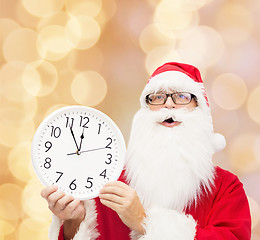 Image showing man in costume of santa claus with clock