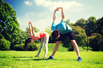 Image showing smiling couple stretching outdoors