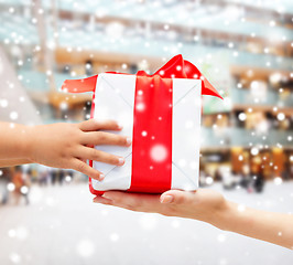 Image showing close up of child and mother hands with gift box